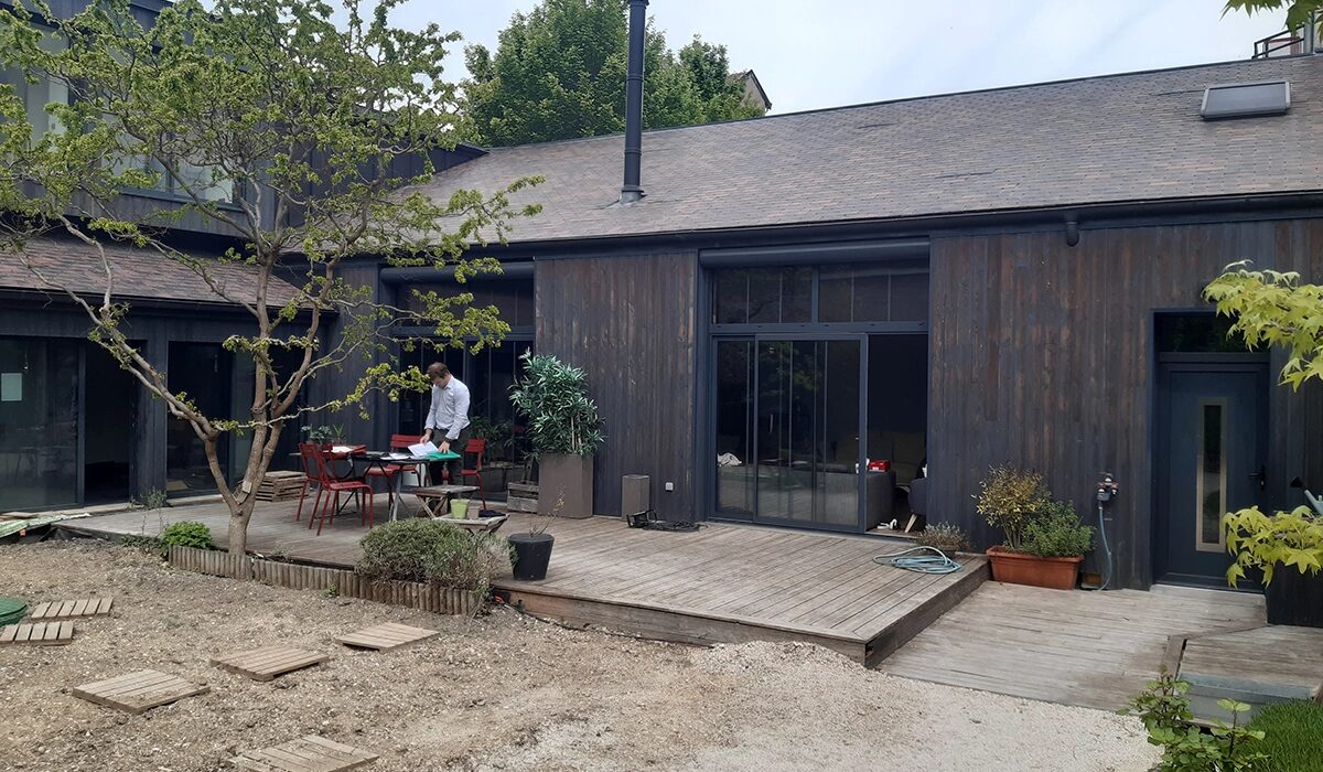 Extérieur avant aménagement : terrain nu et terrasse à reprendre