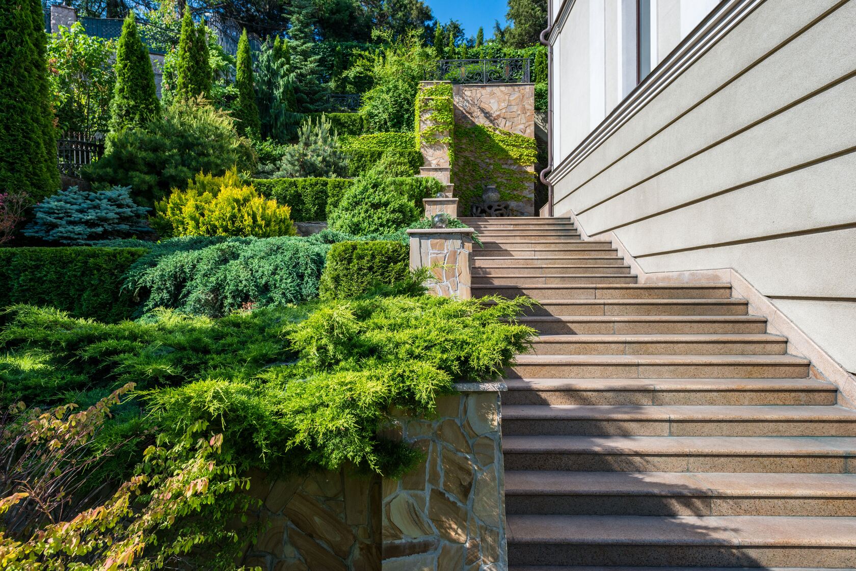 Aménagement paysager et maçonnerie réalisés par TMD Paysage : escalier en pierre, muret et jardin structuré en terrasses